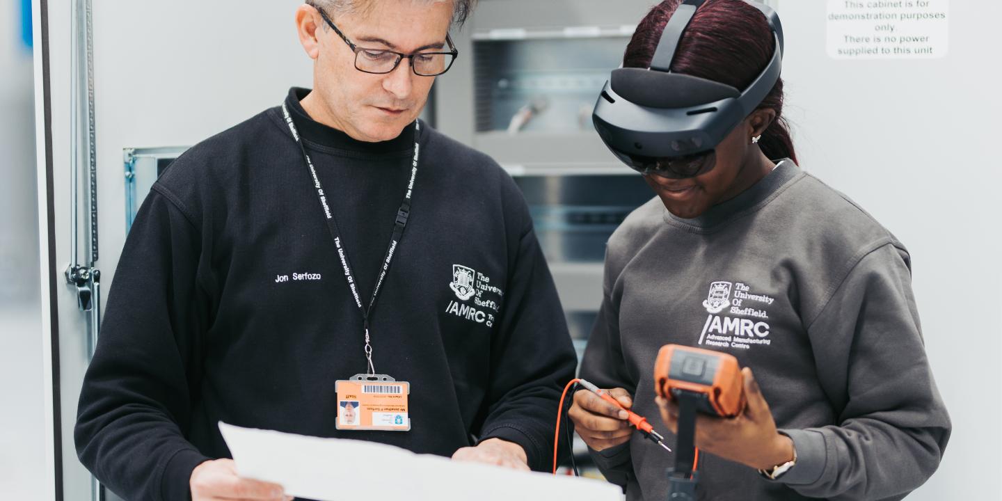 A lecturer at the University of Sheffield helps a student use a VR headset in a manufacturing project 