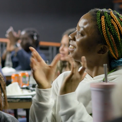 A black woman applauds at an event in Manchester's Black Leadership Programme