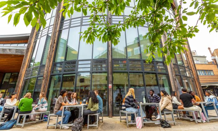 Students sitting outside a Durham University campus building