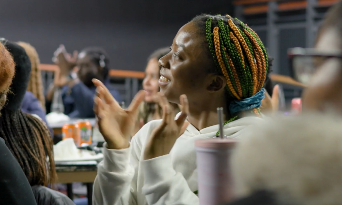 A black woman applauds at an event in Manchester's Black Leadership Programme