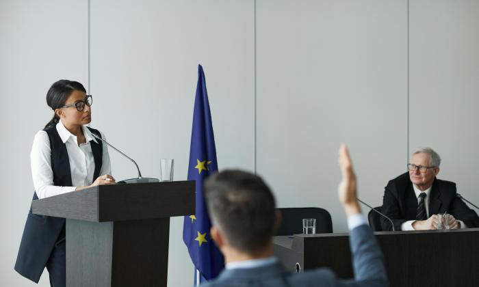 Woman Standing at a Rostrum and Talking during a Political Conference