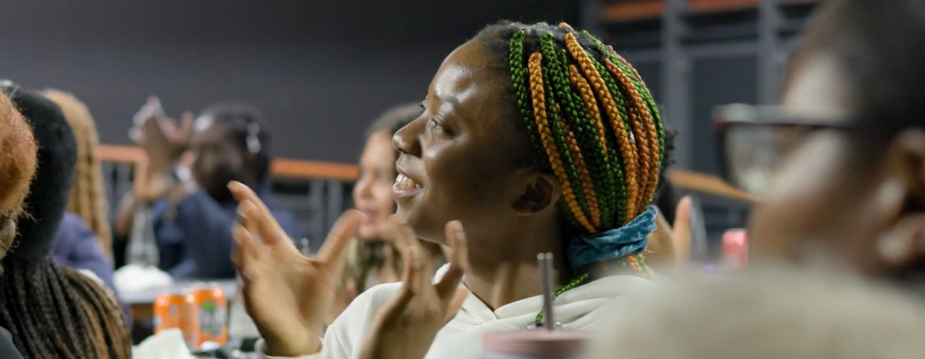 A black woman applauds at an event in Manchester's Black Leadership Programme