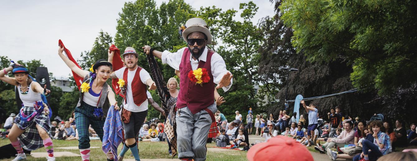 Performers dance outside on the grass at a Turner Sims Southampton family day 