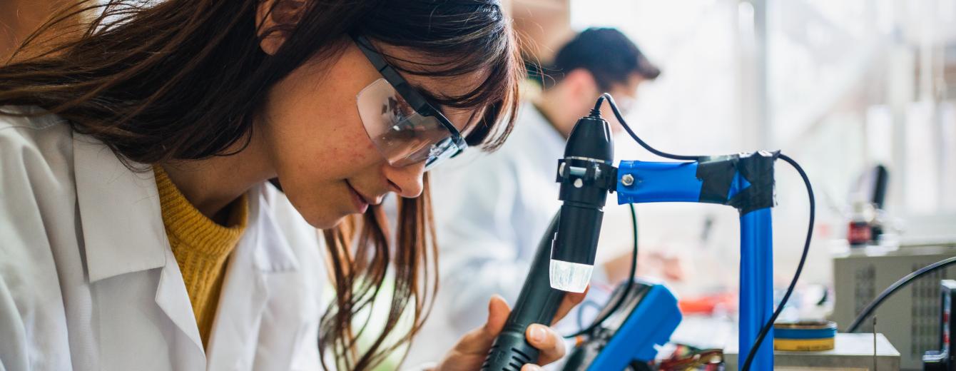 A female student soldering in an electronics class