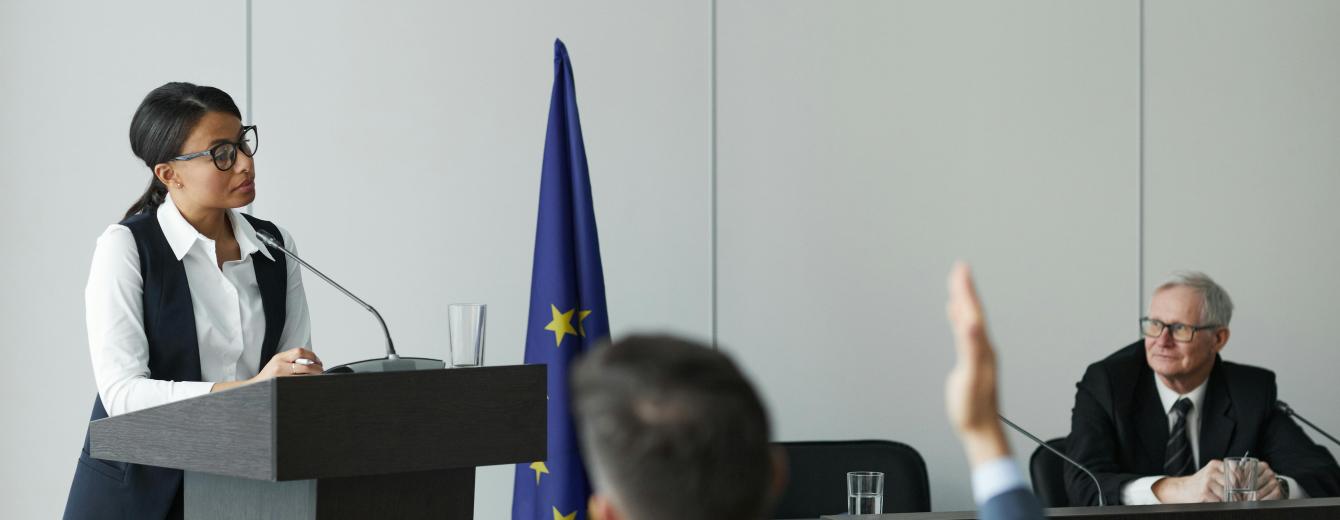 Woman Standing at a Rostrum and Talking during a Political Conference